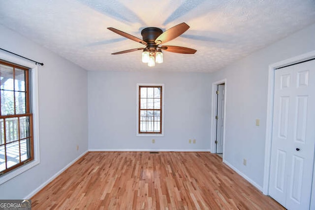 unfurnished bedroom featuring ceiling fan, a textured ceiling, and light hardwood / wood-style floors