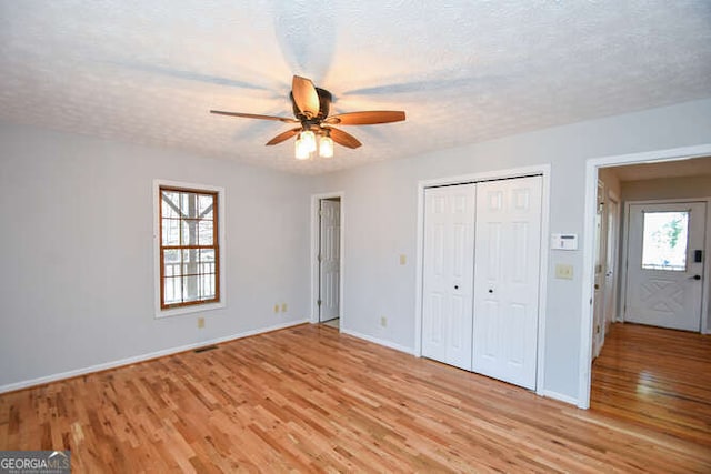 unfurnished bedroom featuring a textured ceiling, ceiling fan, and light hardwood / wood-style flooring