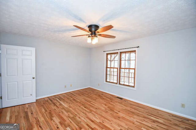 spare room with a textured ceiling, ceiling fan, and light hardwood / wood-style floors