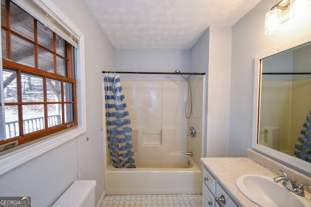 bathroom featuring a textured ceiling, vanity, and shower / tub combo with curtain