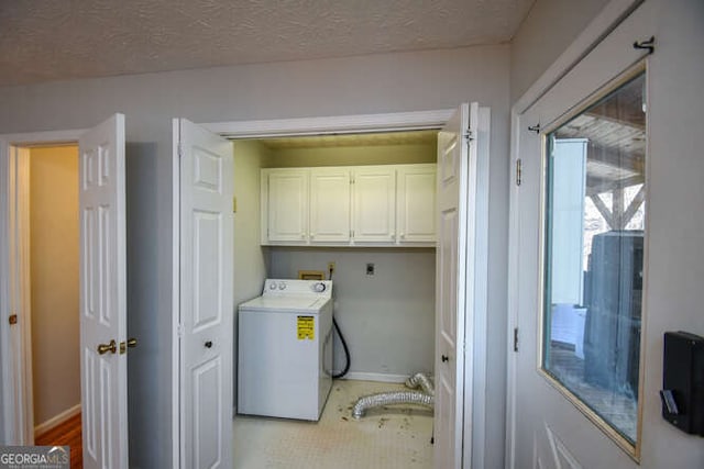 washroom featuring washer / dryer, a textured ceiling, and cabinets