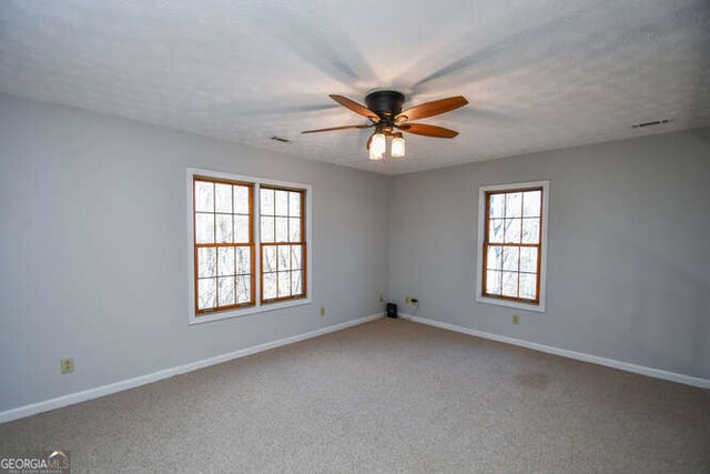 unfurnished bedroom with ceiling fan, light colored carpet, a textured ceiling, and vaulted ceiling