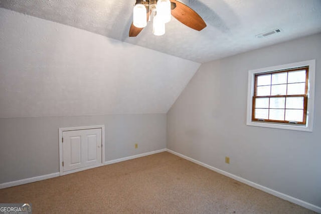 bonus room featuring carpet floors, a textured ceiling, ceiling fan, and vaulted ceiling