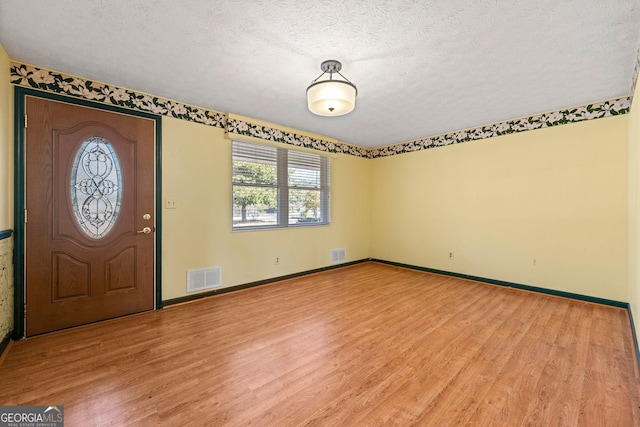 entryway featuring a textured ceiling and light wood-type flooring