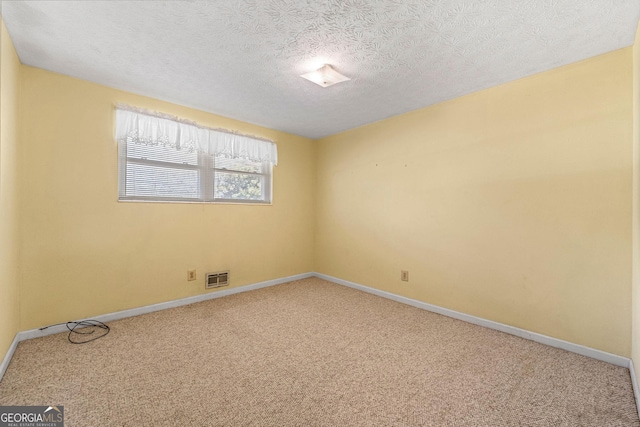 spare room featuring a textured ceiling and carpet