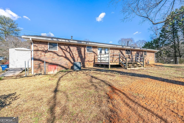 back of property featuring a wooden deck and a lawn