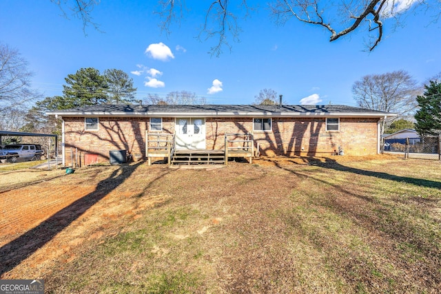 back of property with a deck and a lawn