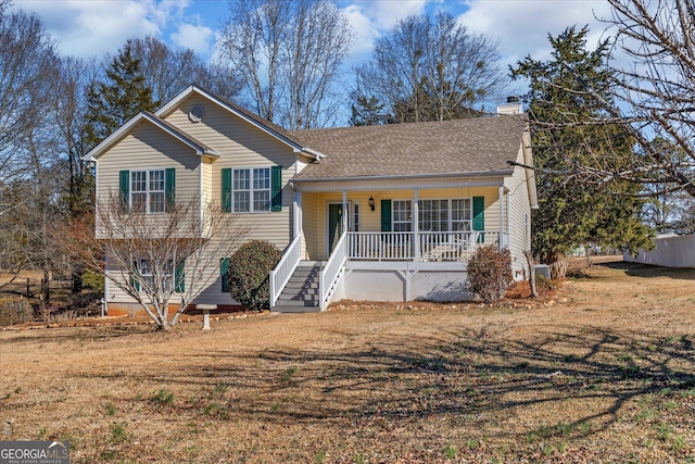 tri-level home with covered porch and a front yard