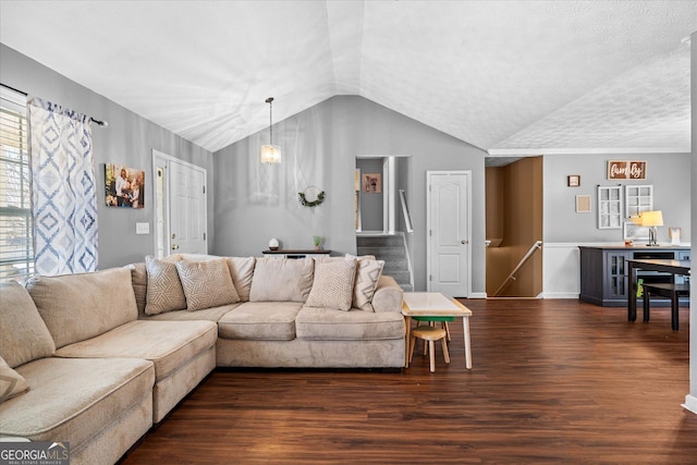 living room with dark hardwood / wood-style flooring, a notable chandelier, and vaulted ceiling