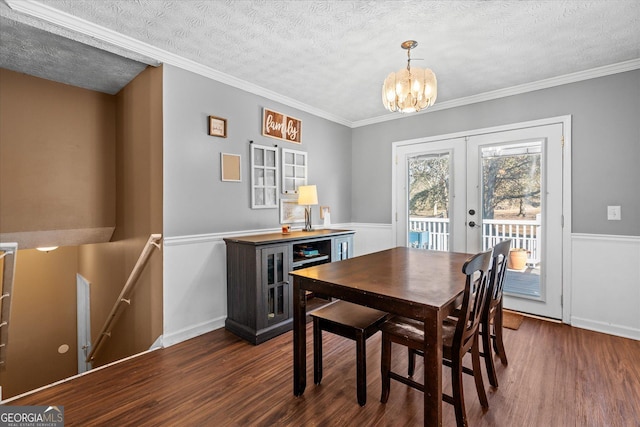 dining area featuring dark hardwood / wood-style flooring, french doors, a textured ceiling, a chandelier, and crown molding