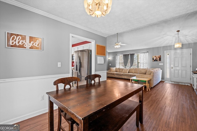 dining room with ceiling fan with notable chandelier, a textured ceiling, dark hardwood / wood-style floors, and ornamental molding