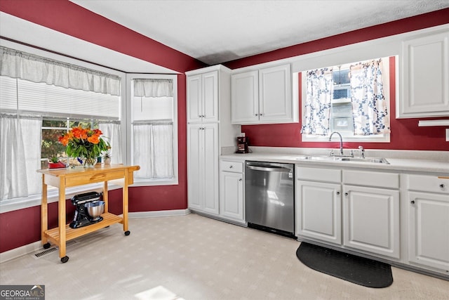 kitchen featuring stainless steel dishwasher, white cabinets, and sink