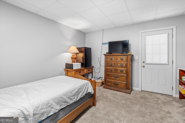 bedroom with light carpet and a drop ceiling