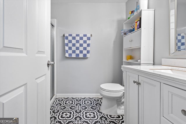 bathroom featuring a shower with shower door, tile patterned floors, toilet, and vanity