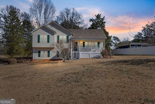 tri-level home with a porch and a lawn