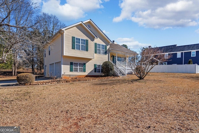 front facade with a front yard, covered porch, and a garage