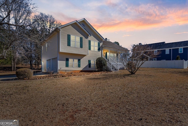 view of front of property with a lawn, covered porch, and a garage