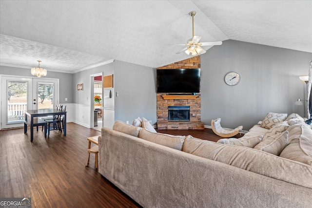 living room featuring a stone fireplace, ceiling fan, dark hardwood / wood-style floors, lofted ceiling, and a textured ceiling