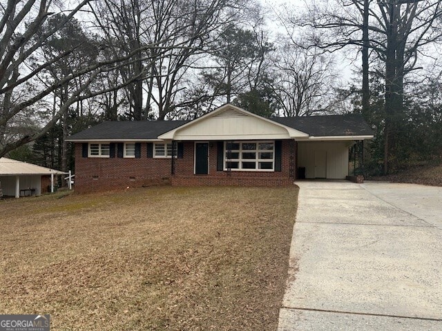 single story home featuring a front lawn and a carport