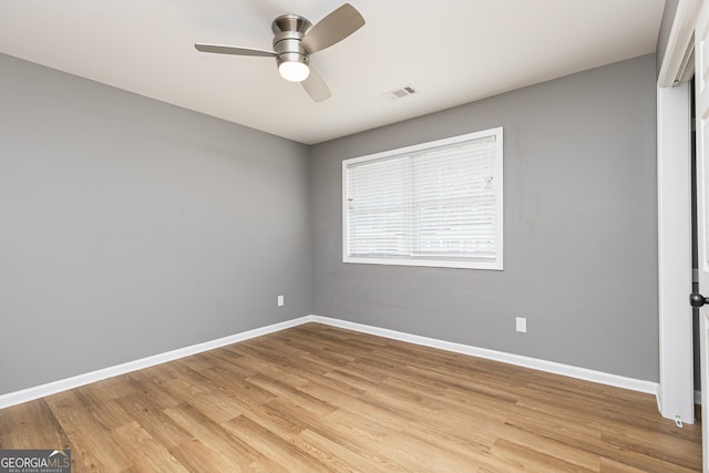 empty room with ceiling fan and light hardwood / wood-style flooring