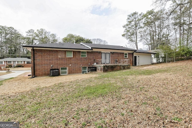 back of house featuring a lawn and central air condition unit