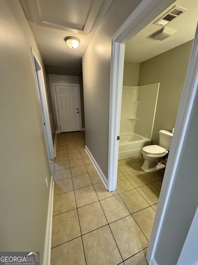 bathroom featuring bathtub / shower combination, tile patterned floors, and toilet