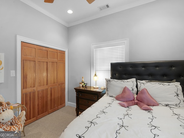 carpeted bedroom with a closet, crown molding, and ceiling fan