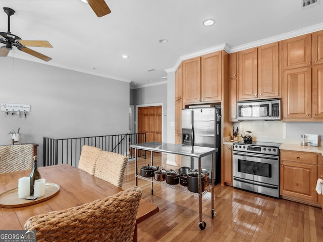 kitchen featuring appliances with stainless steel finishes, backsplash, ornamental molding, light wood-type flooring, and ceiling fan