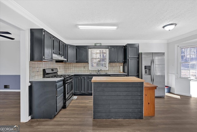 kitchen featuring appliances with stainless steel finishes, crown molding, wooden counters, and sink