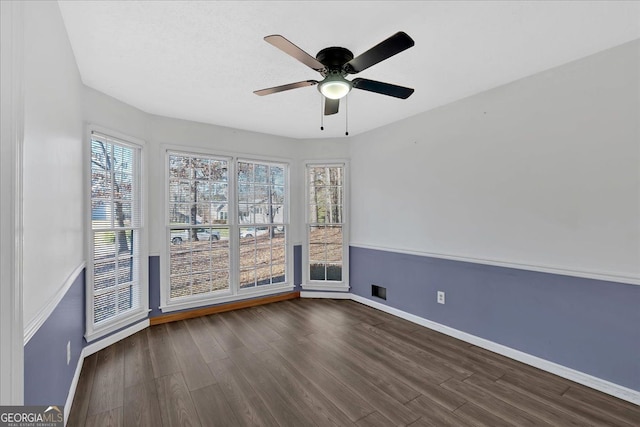 unfurnished room with ceiling fan and dark wood-type flooring