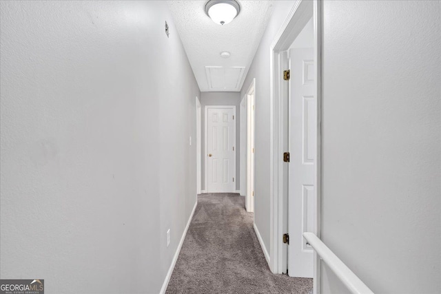 hallway featuring a textured ceiling and carpet floors