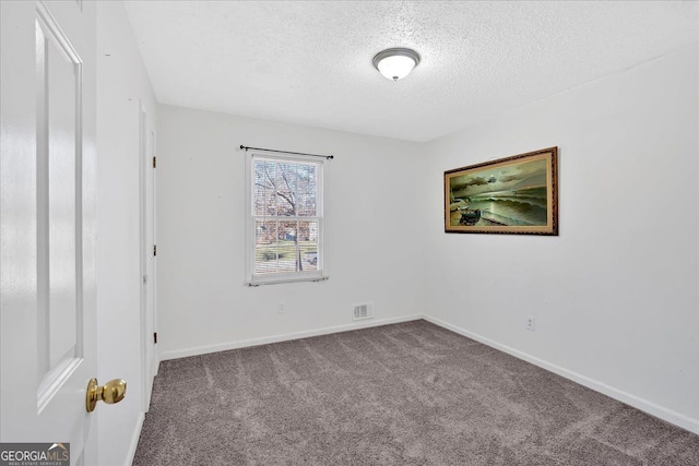 carpeted empty room with a textured ceiling