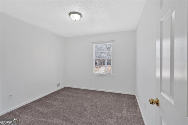 empty room featuring a textured ceiling and carpet flooring