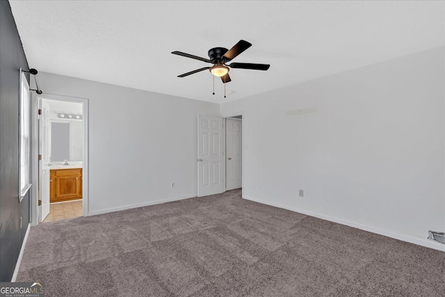 unfurnished bedroom featuring ensuite bath, sink, ceiling fan, and light carpet