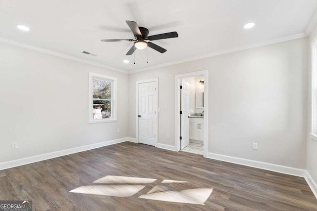 unfurnished bedroom featuring dark hardwood / wood-style floors, ceiling fan, connected bathroom, and crown molding