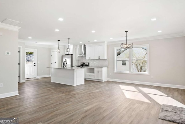 kitchen with white cabinetry, decorative light fixtures, stainless steel appliances, and wall chimney exhaust hood