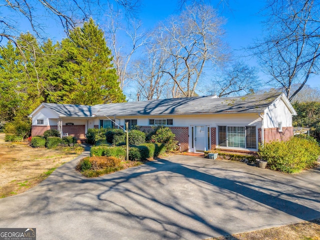 single story home featuring brick siding and driveway