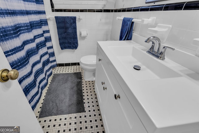 bathroom with tile patterned flooring, toilet, a shower with shower curtain, vanity, and tile walls