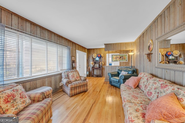 living room featuring light hardwood / wood-style floors and wood walls