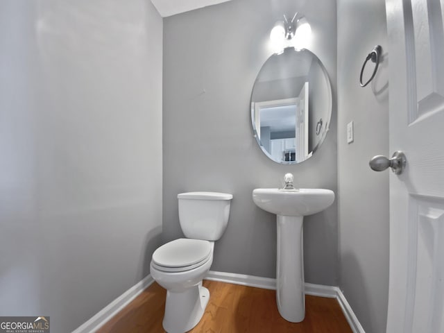 bathroom featuring hardwood / wood-style flooring and toilet