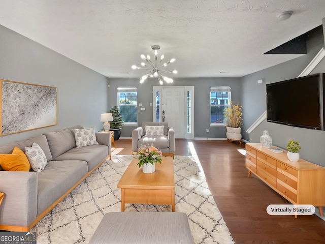 living room featuring hardwood / wood-style flooring and an inviting chandelier