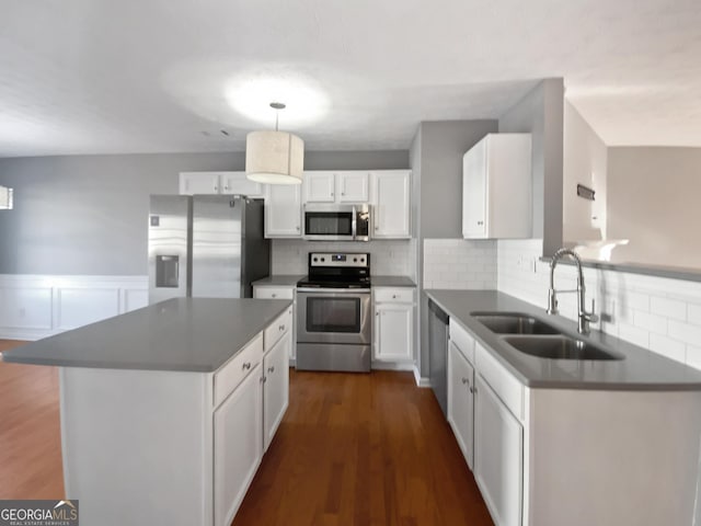 kitchen featuring pendant lighting, sink, white cabinets, tasteful backsplash, and stainless steel appliances