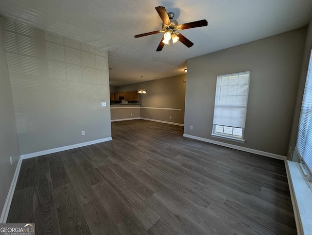 unfurnished living room featuring ceiling fan and dark wood-type flooring