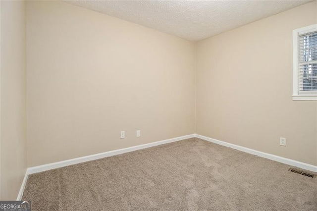 unfurnished room with carpet floors and a textured ceiling