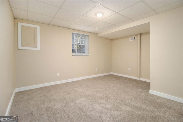 basement featuring carpet floors, electric panel, and a paneled ceiling