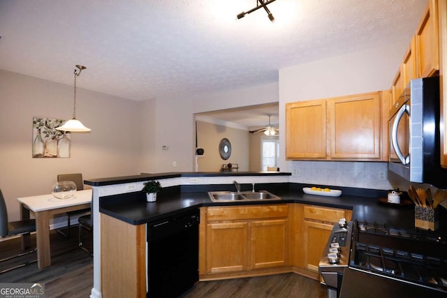 kitchen featuring stainless steel appliances, dark hardwood / wood-style flooring, kitchen peninsula, and sink