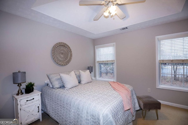 carpeted bedroom with visible vents, ceiling fan, and baseboards