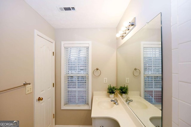 bathroom featuring double vanity, a sink, and visible vents