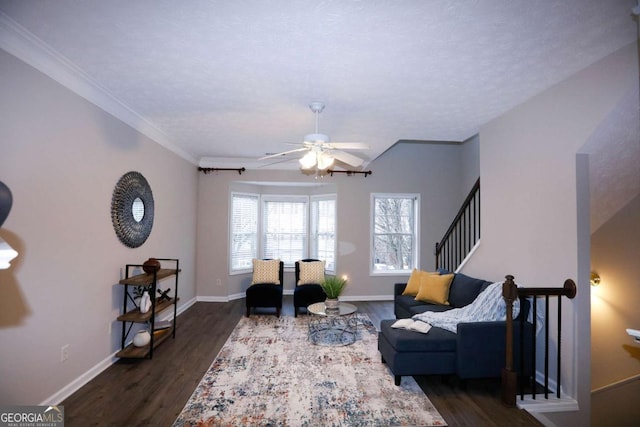 sitting room featuring a ceiling fan, baseboards, stairway, dark wood-style floors, and crown molding