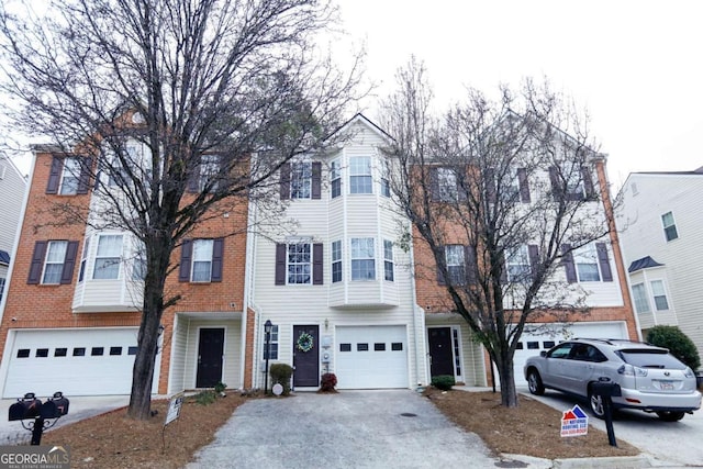 multi unit property featuring a garage and aphalt driveway